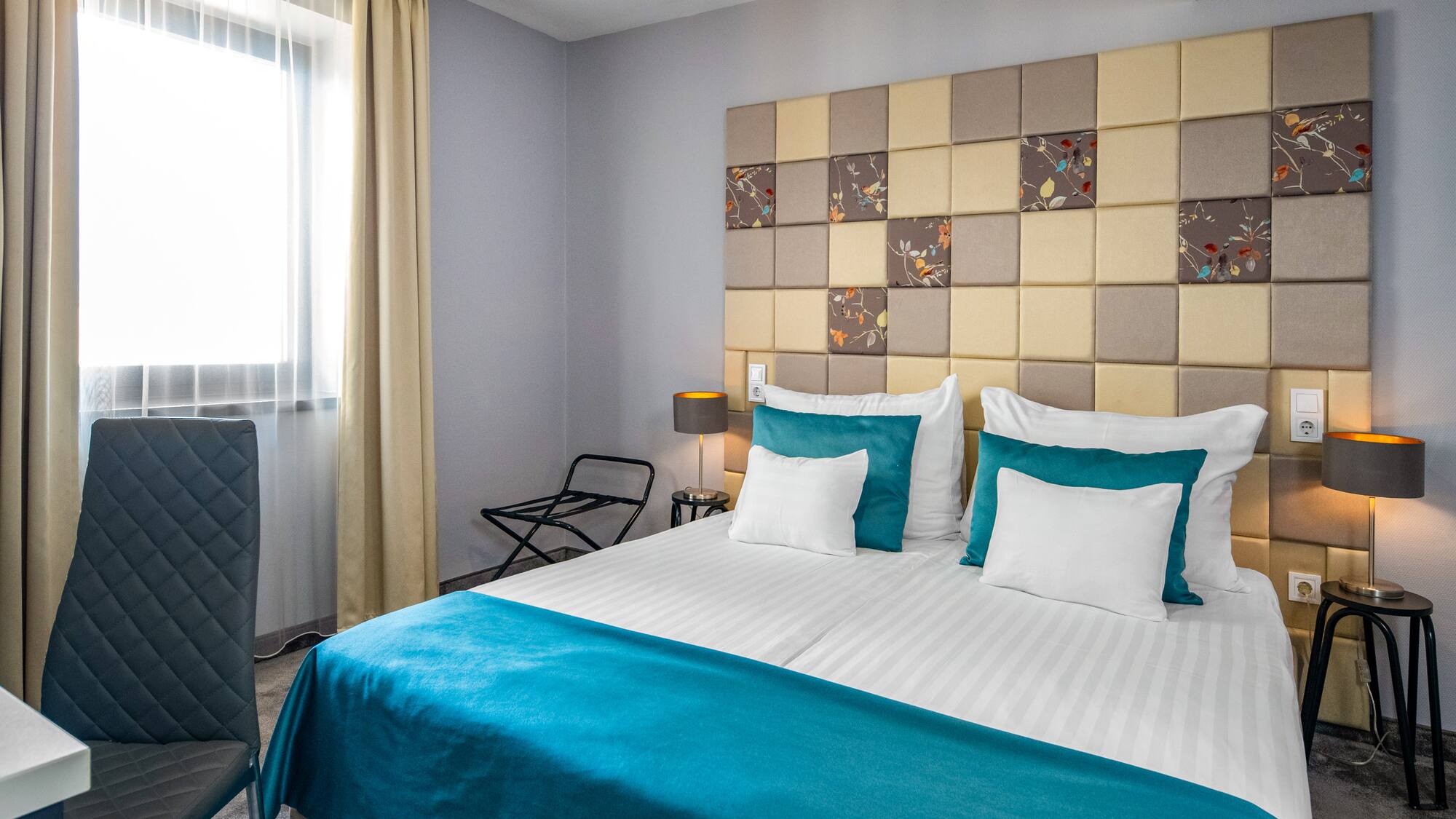 a bed with a blue blanket and a lamp in a room