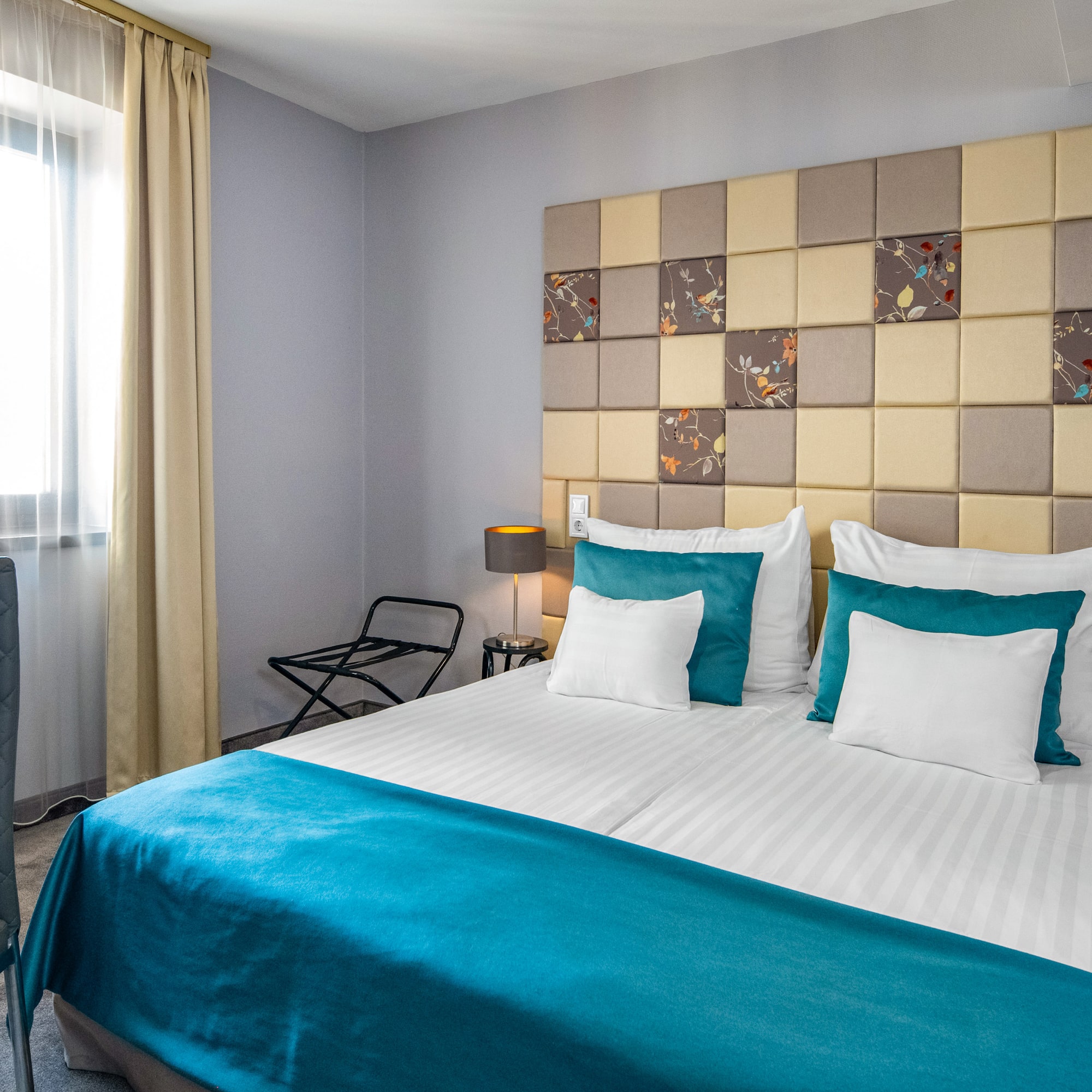 a bed with a blue blanket and a lamp in a room