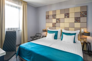 a bed with a blue blanket and a lamp in a room