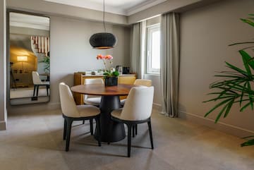 a dining table with chairs and a plant in a room