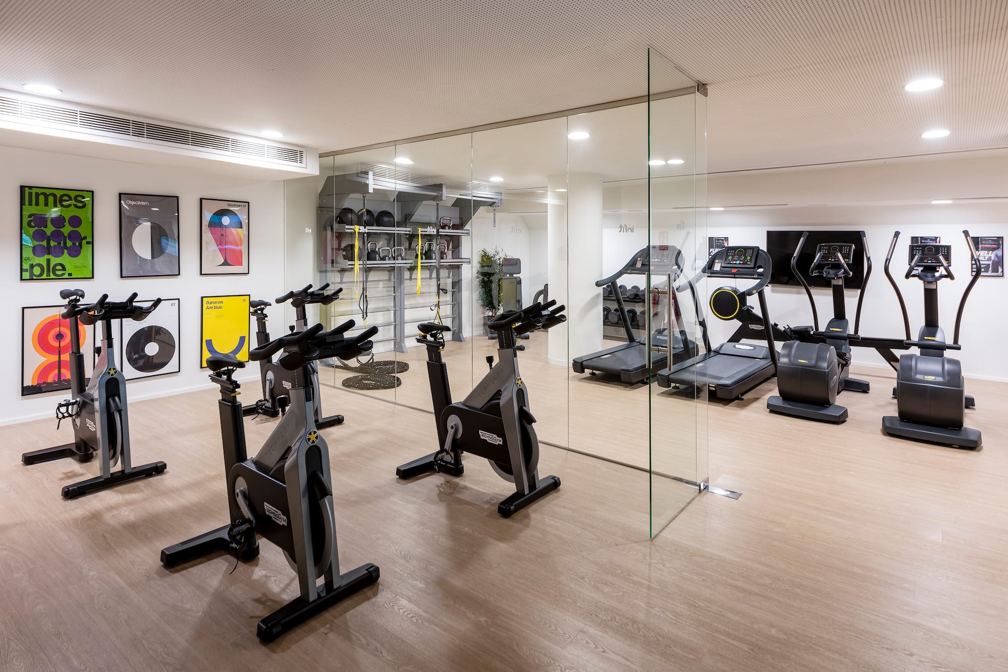 Gimnasio moderno con bicicletas estáticas, cintas de correr y pesas.