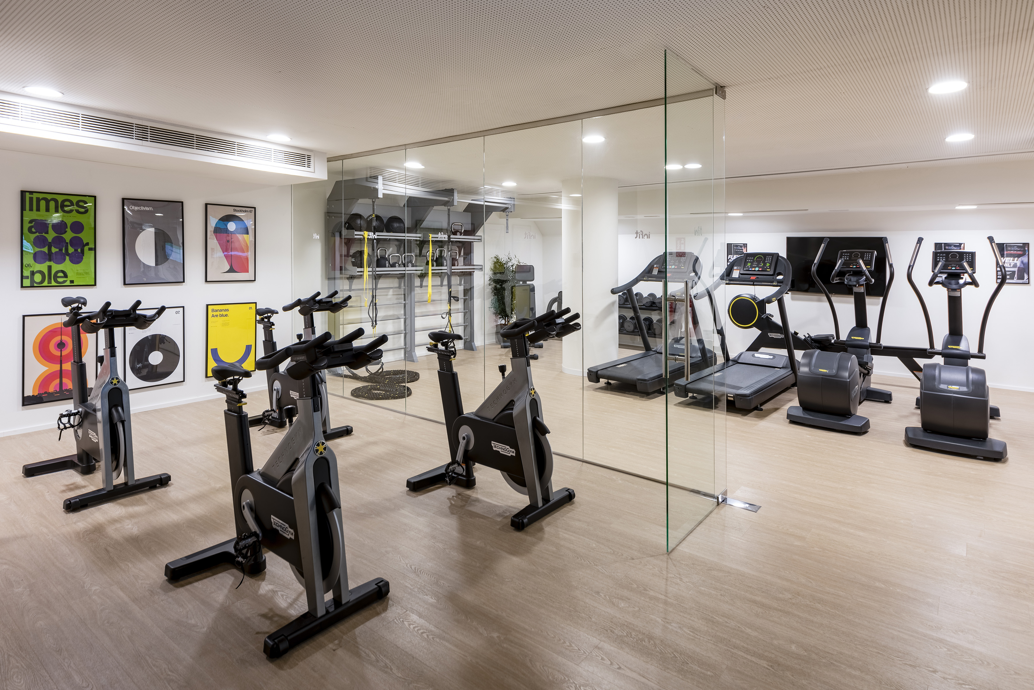 Gimnasio moderno con bicicletas estáticas, cintas de correr y pesas.