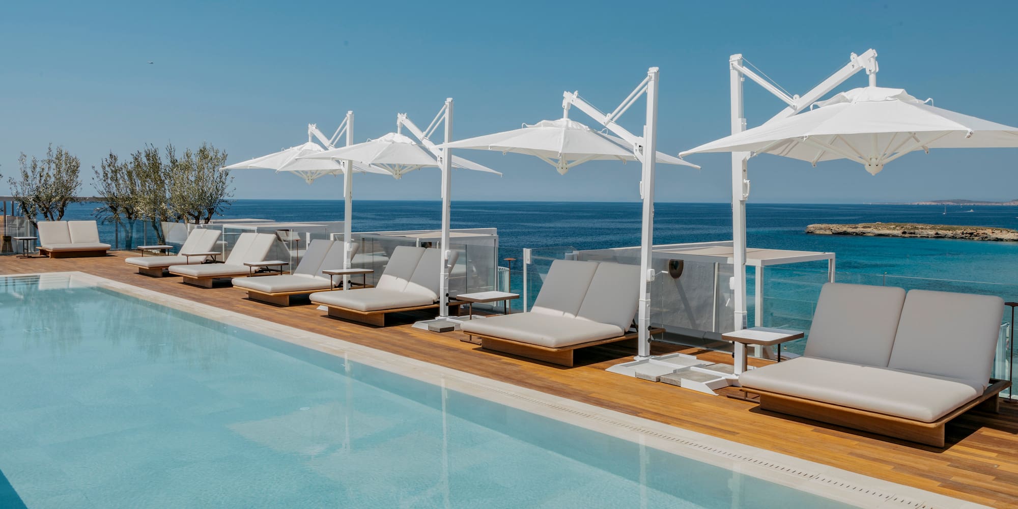 a pool with lounge chairs and umbrellas