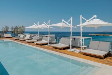 a pool with lounge chairs and umbrellas