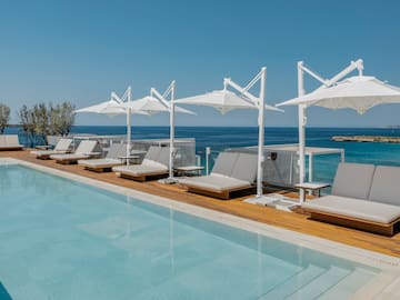 a pool with lounge chairs and umbrellas