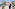 Bride and groom kissing under floral arch at tropical outdoor wedding.