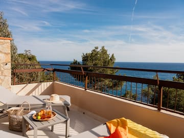 a balcony with a table and chairs overlooking the ocean