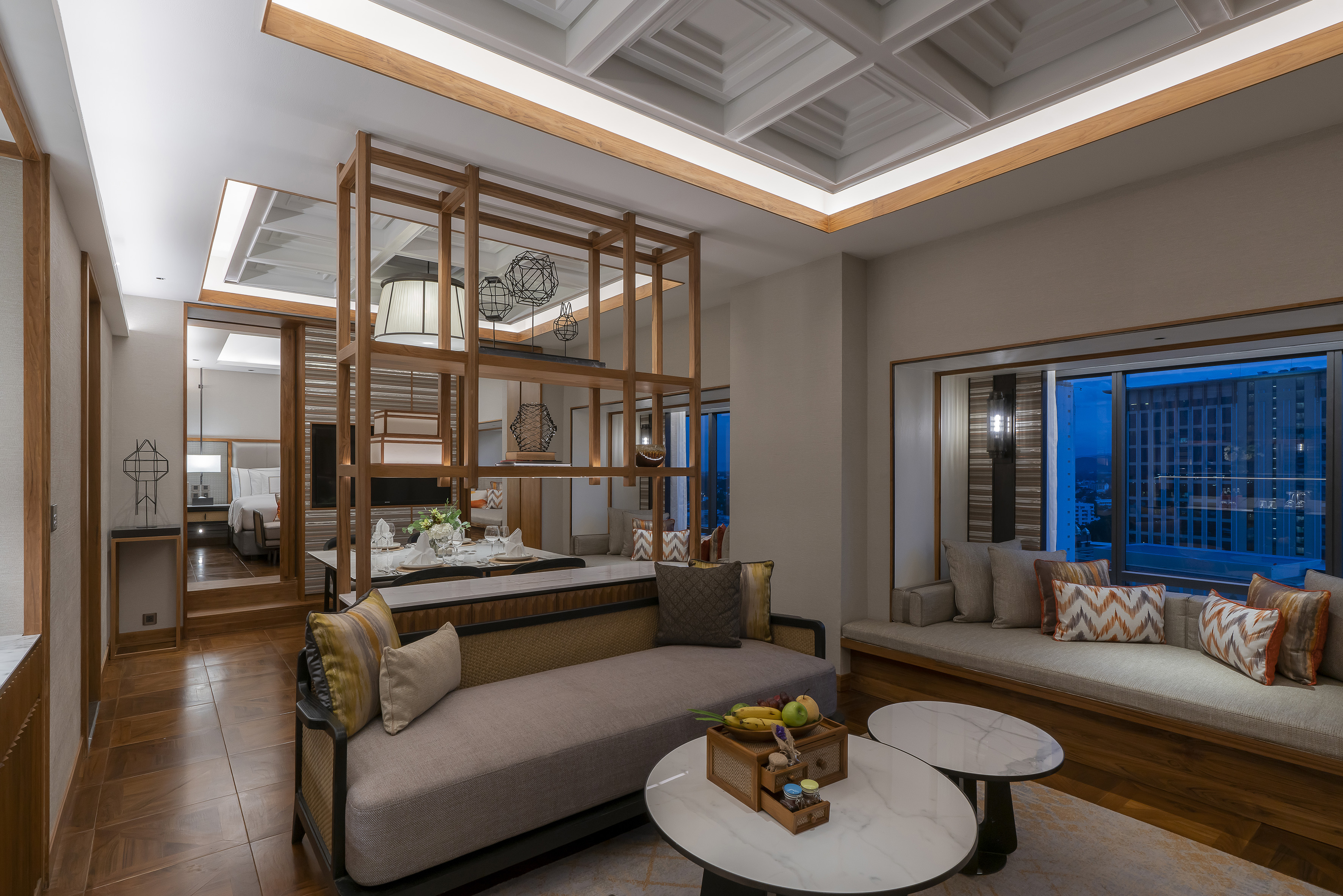 Luxury suite living room with modern wood accents, sofa, and city view.