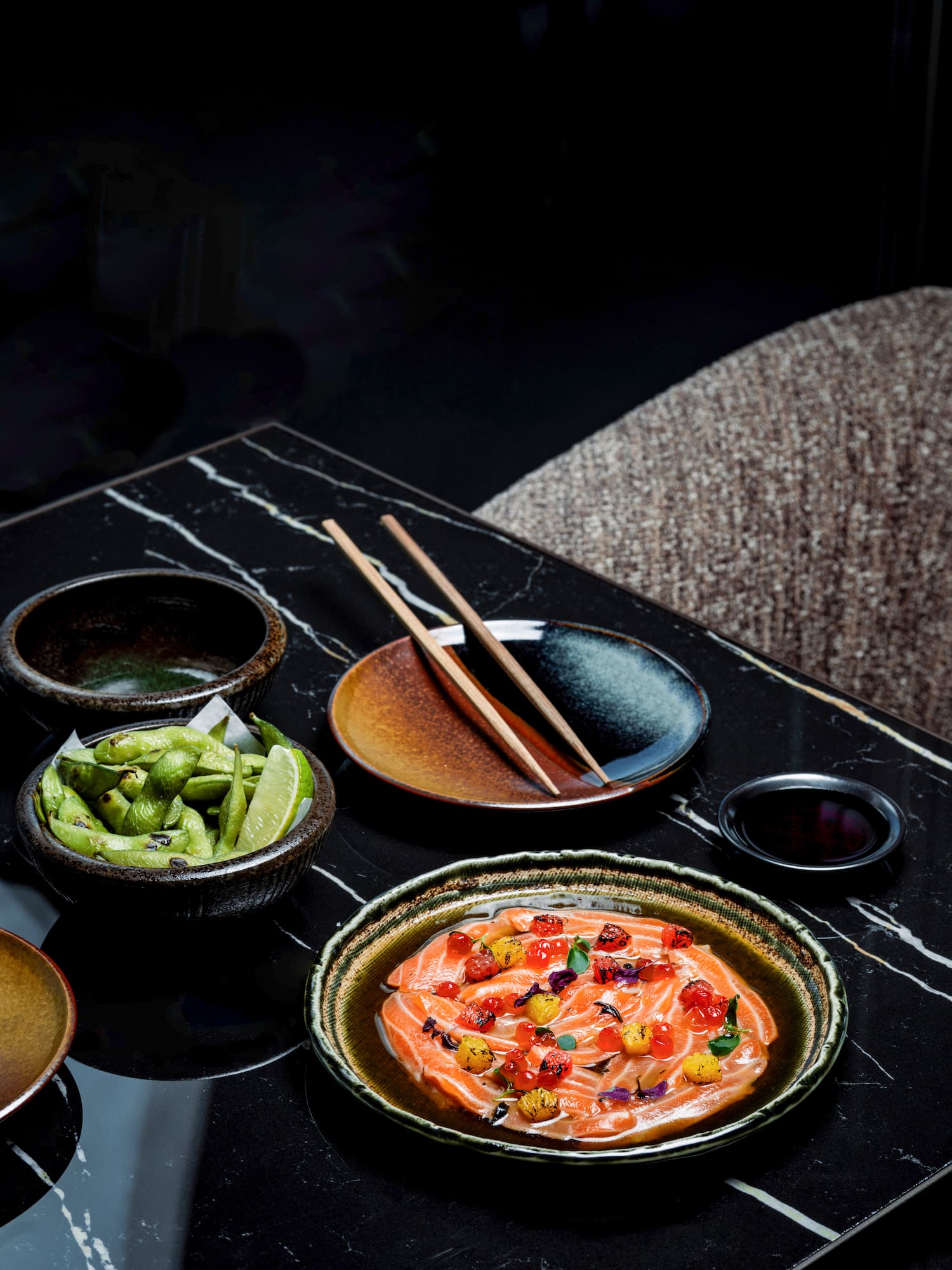 a table with bowls of food and chopsticks