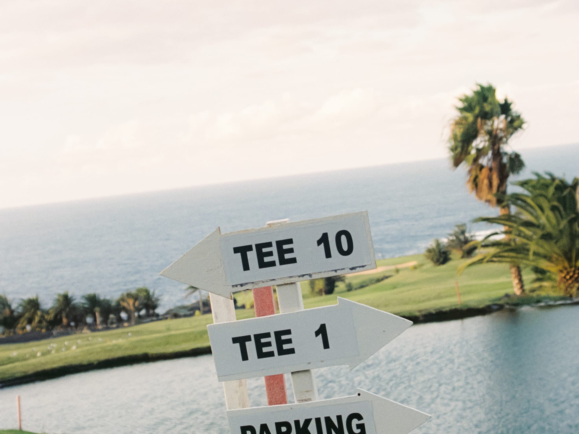 a sign with a body of water and a golf course