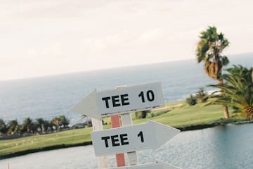 a sign with a body of water and a golf course