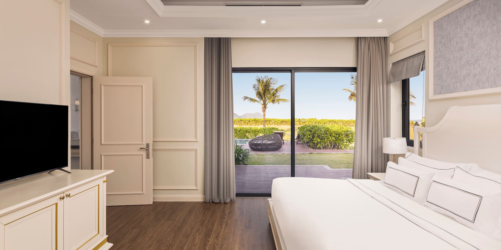 a bedroom with a large bed and a glass door