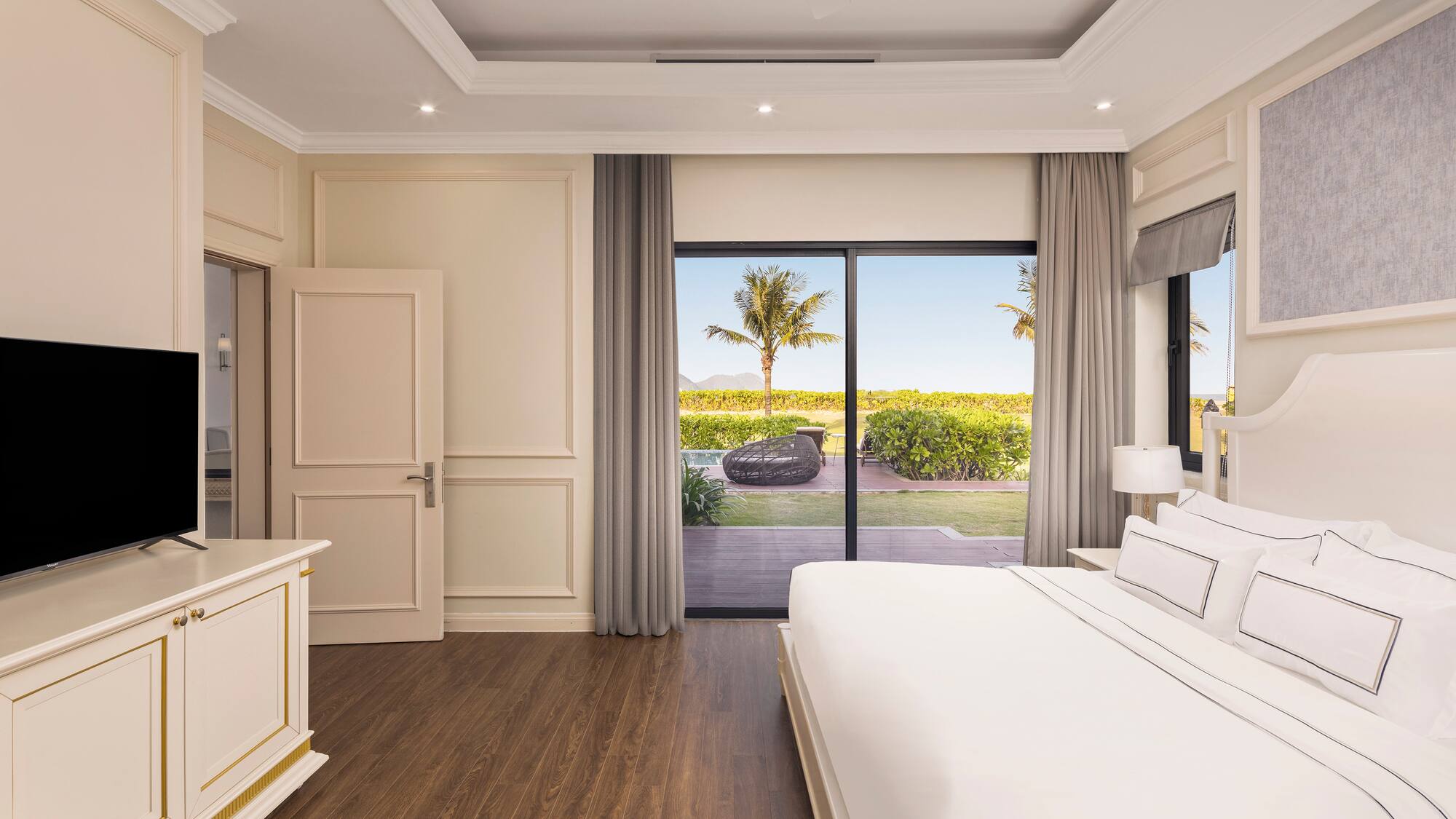 a bedroom with a large bed and a glass door