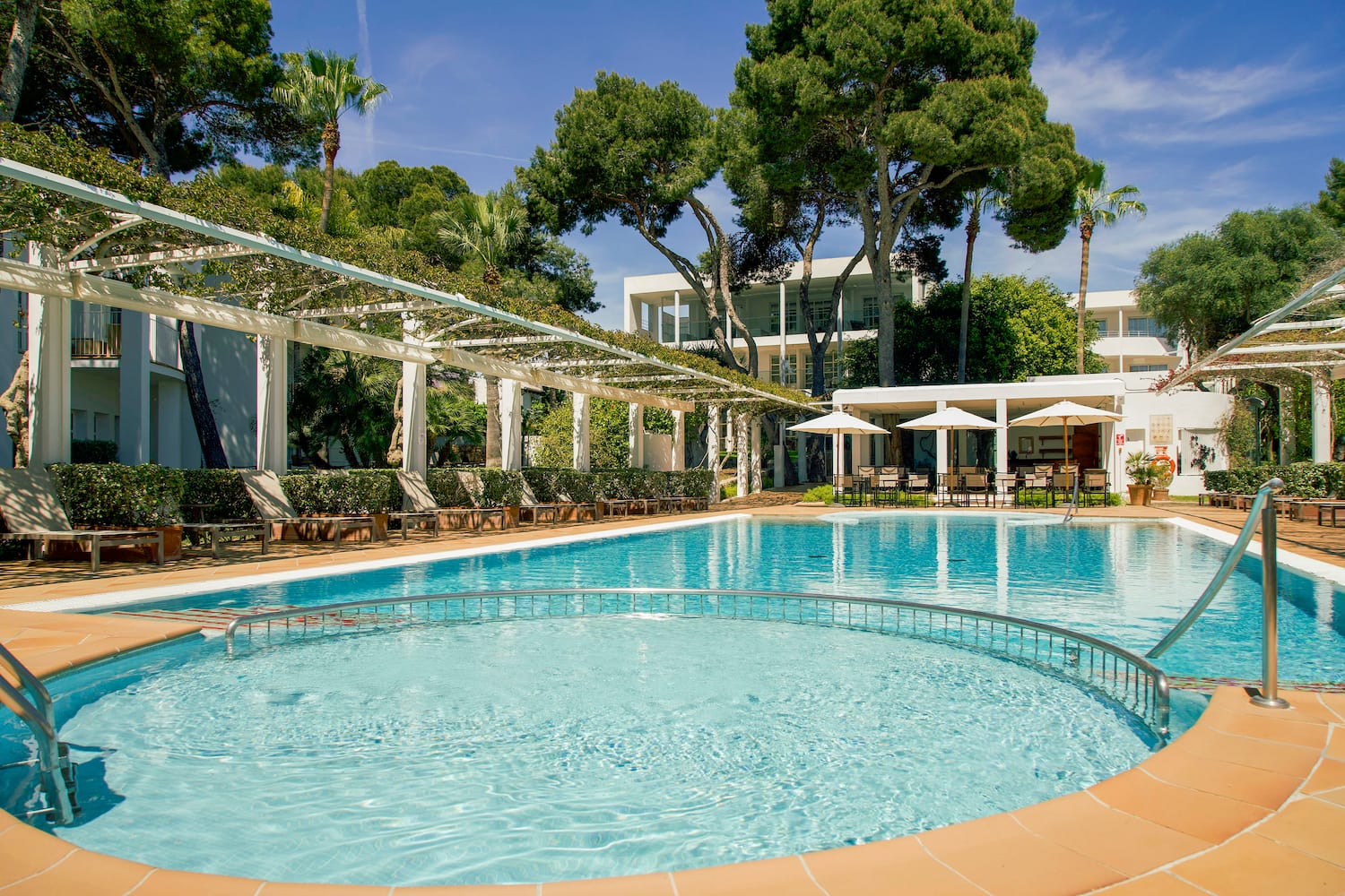 a pool with chairs and a white roof