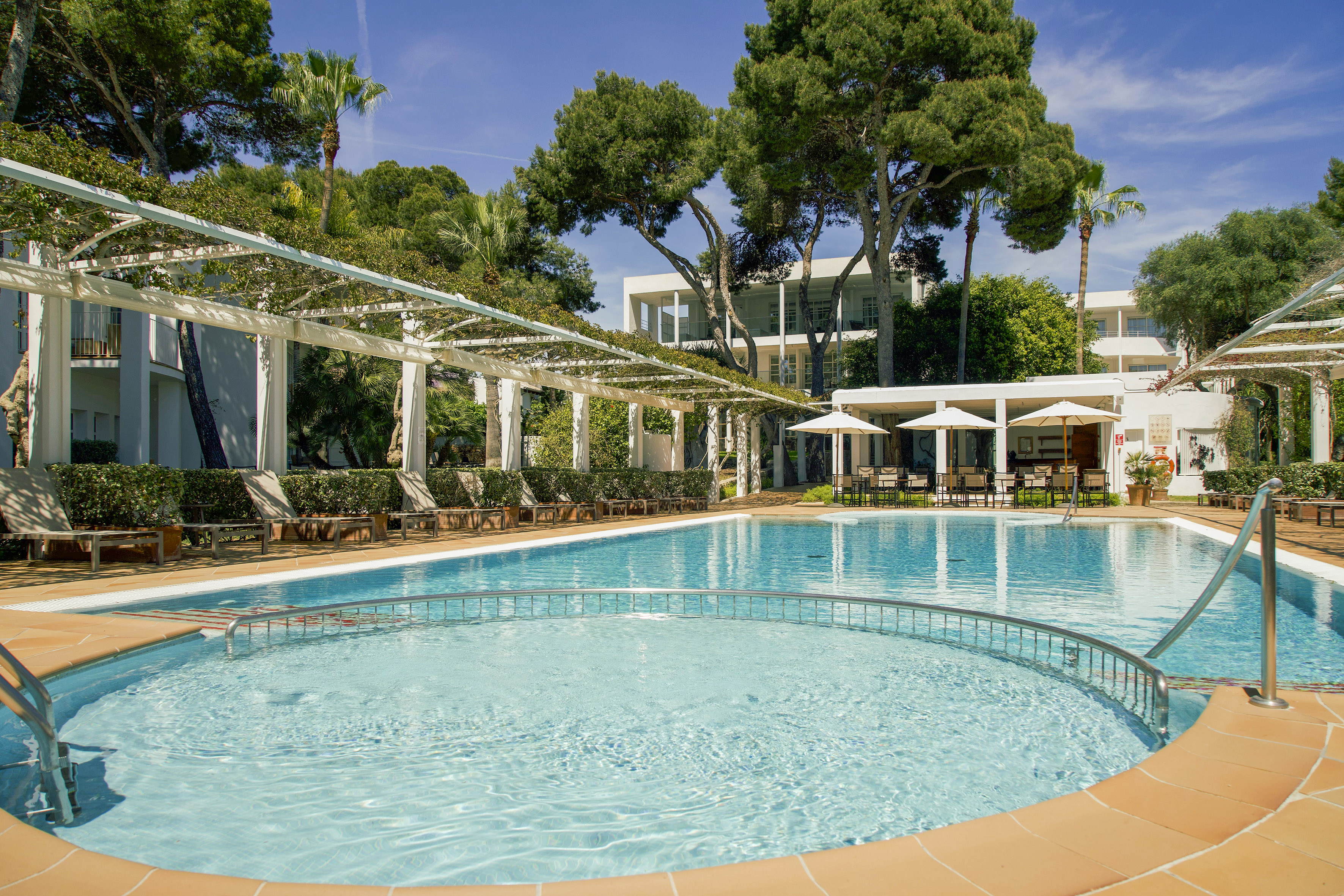 Sunny resort pool, lounge chairs, leafy pergola, and modern hotel building. - Piscine paesaggistiche sorprendenti - Meliá Cala d'Or Boutique Hotel, Maiorca