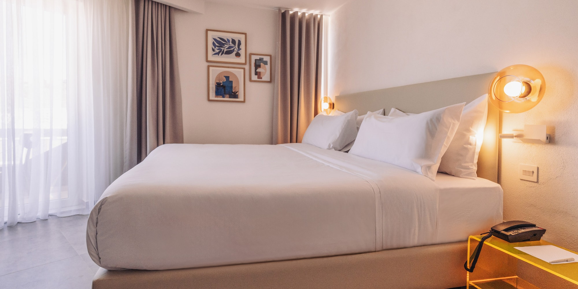 a bed with white sheets and pillows