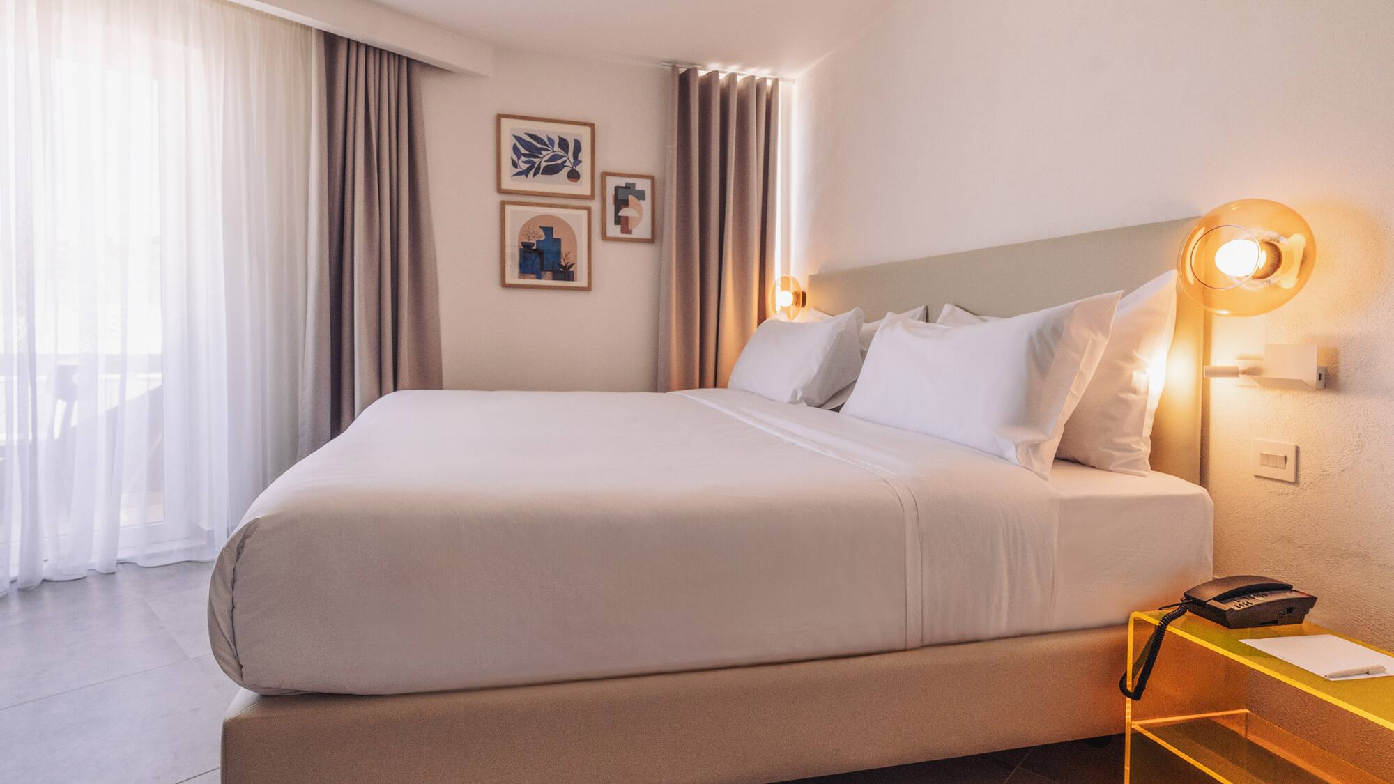 a bed with white sheets and pillows