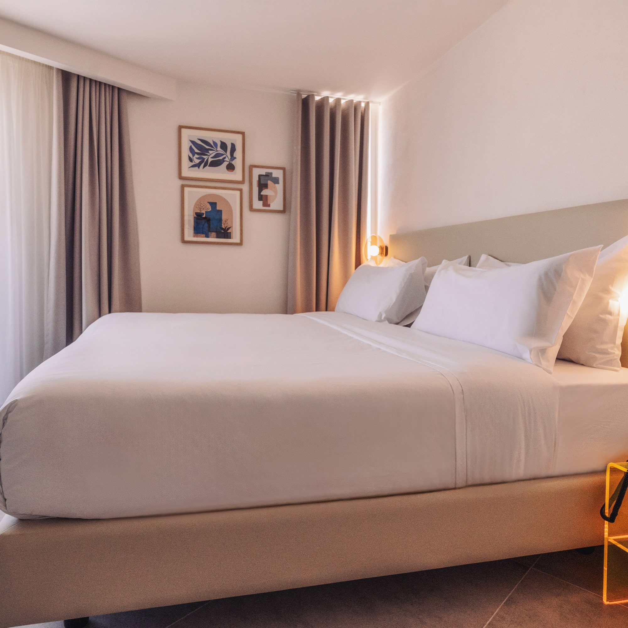 a bed with white sheets and pillows