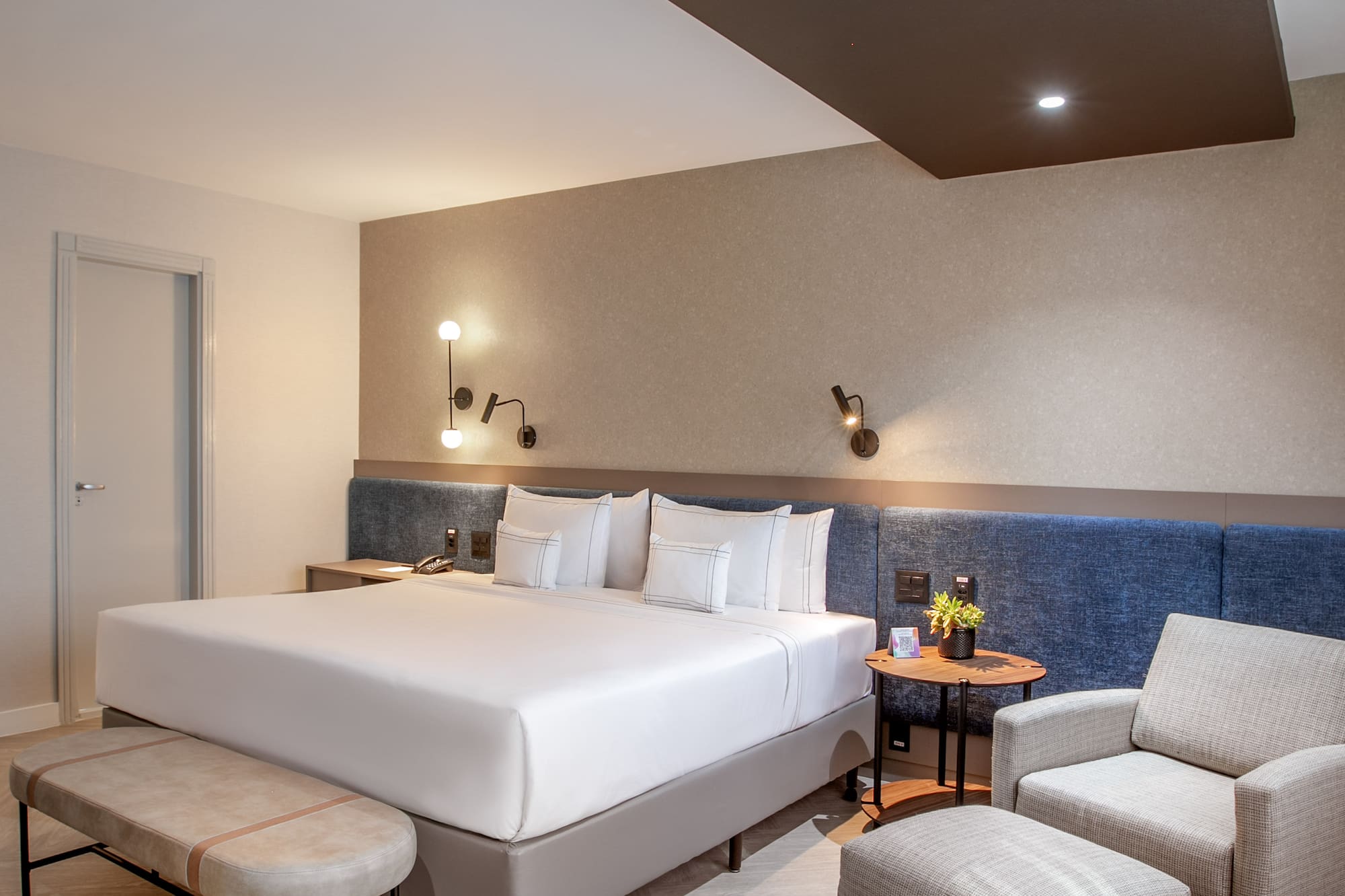 a room with a bed and chairs