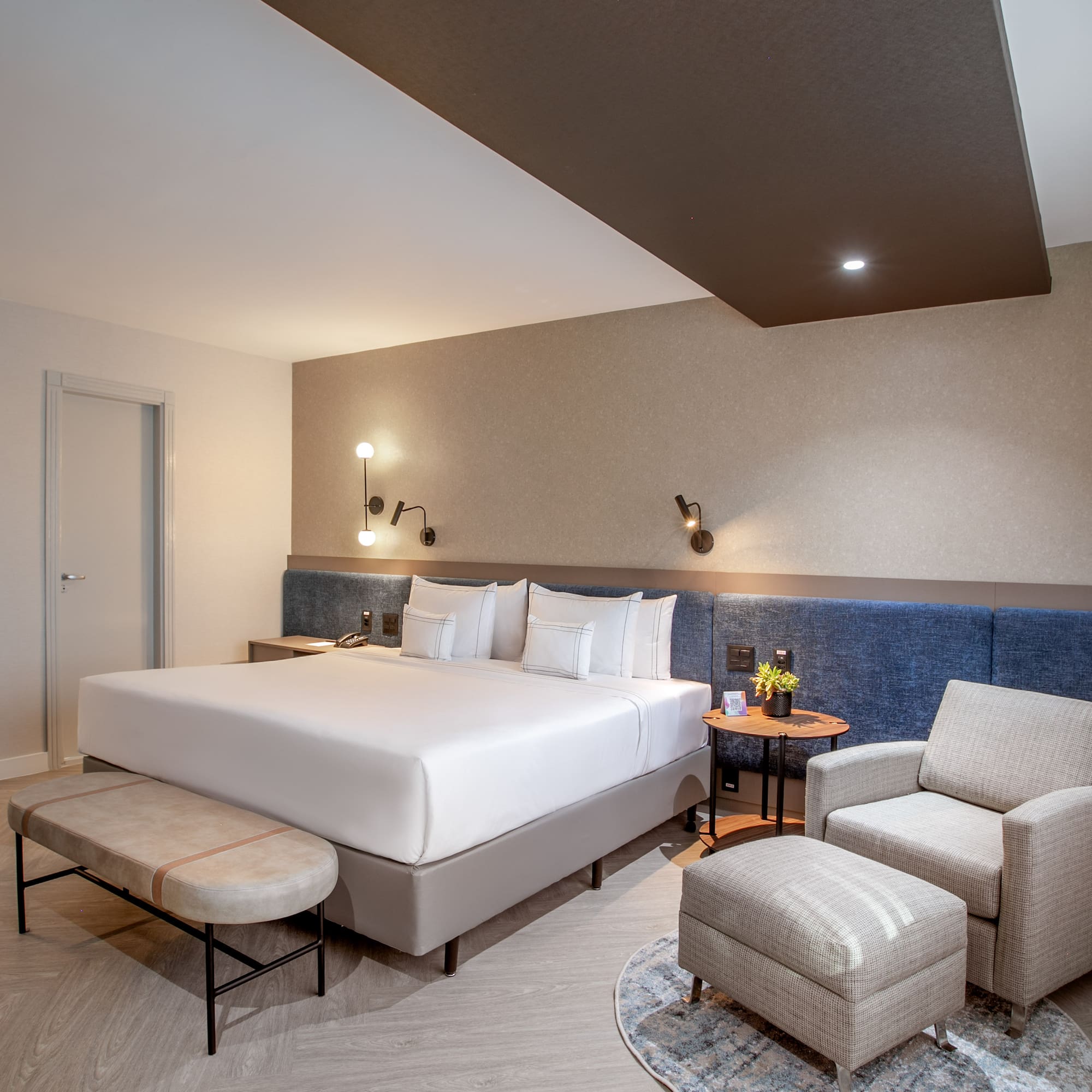 a room with a bed and chairs