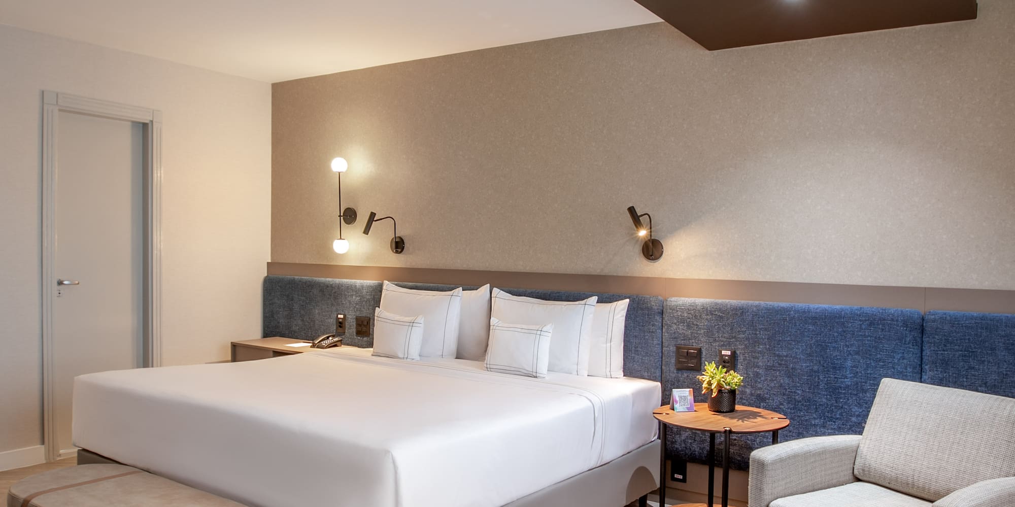 a room with a bed and chairs