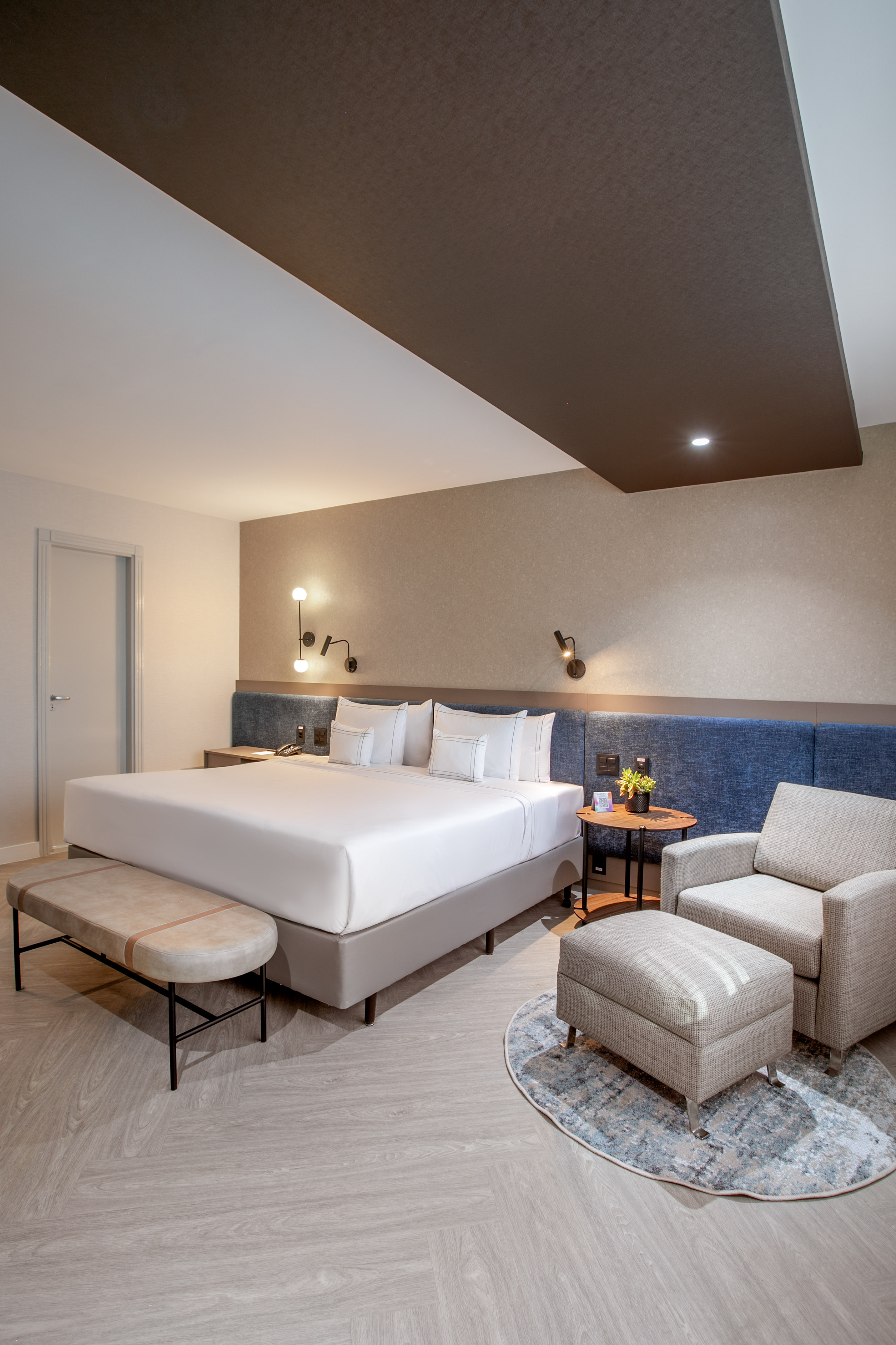 a room with a bed and chairs