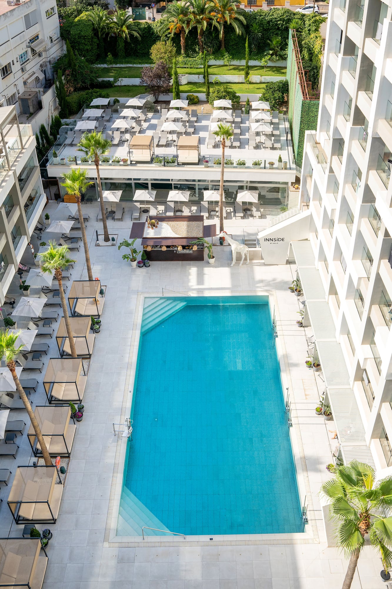 a swimming pool and a building with palm trees