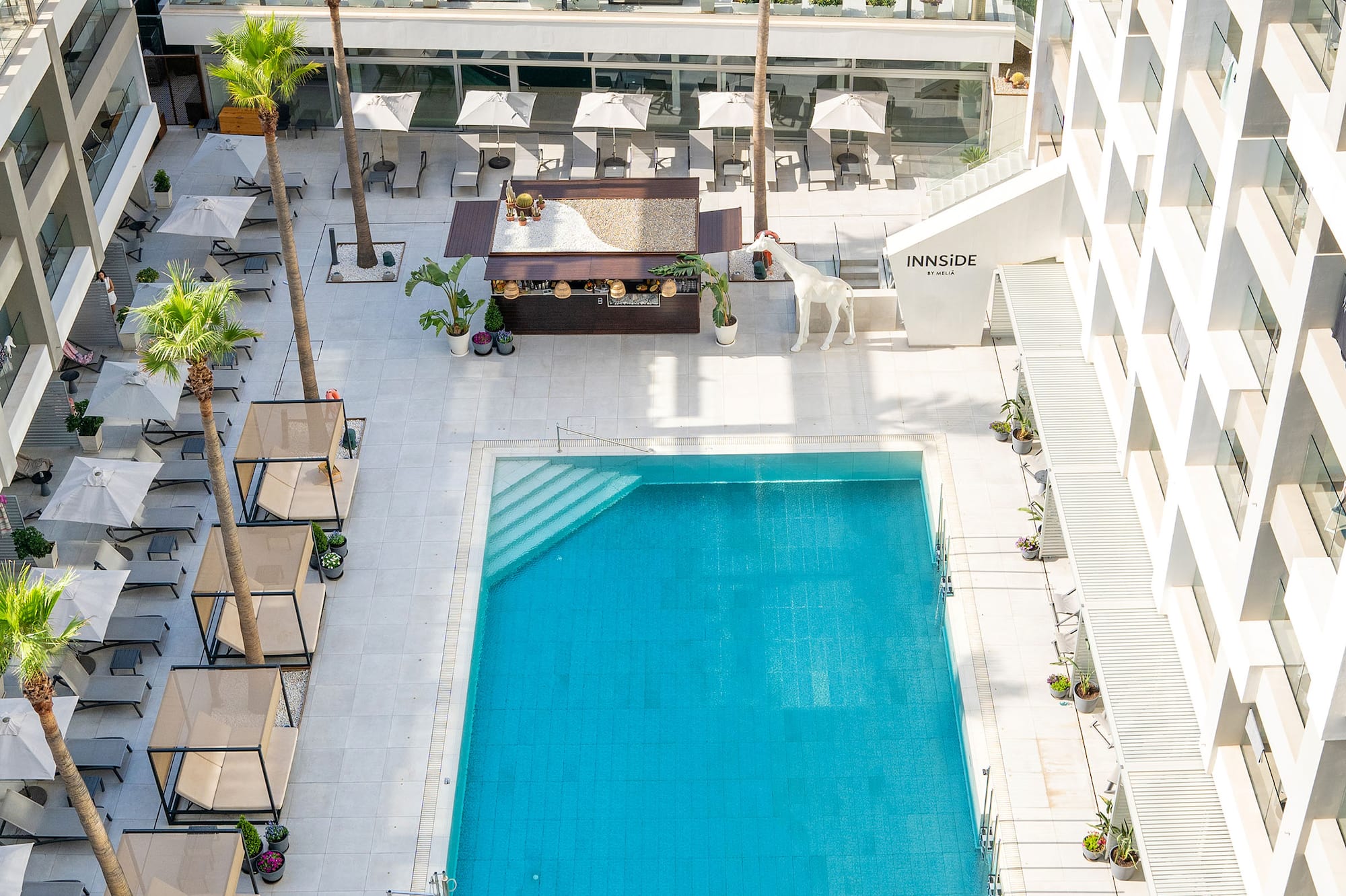 a swimming pool and a building with palm trees