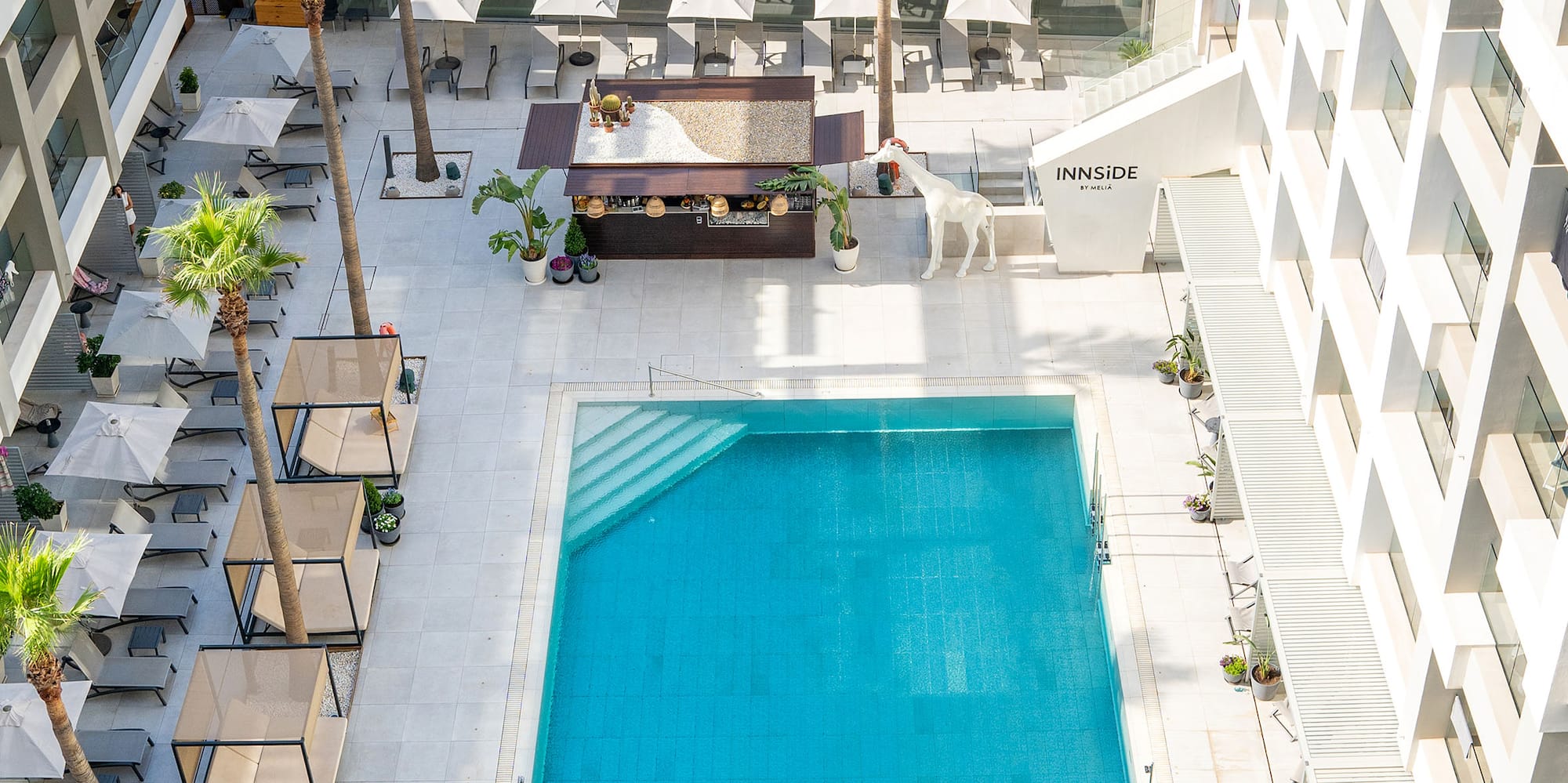 a swimming pool and a building with palm trees