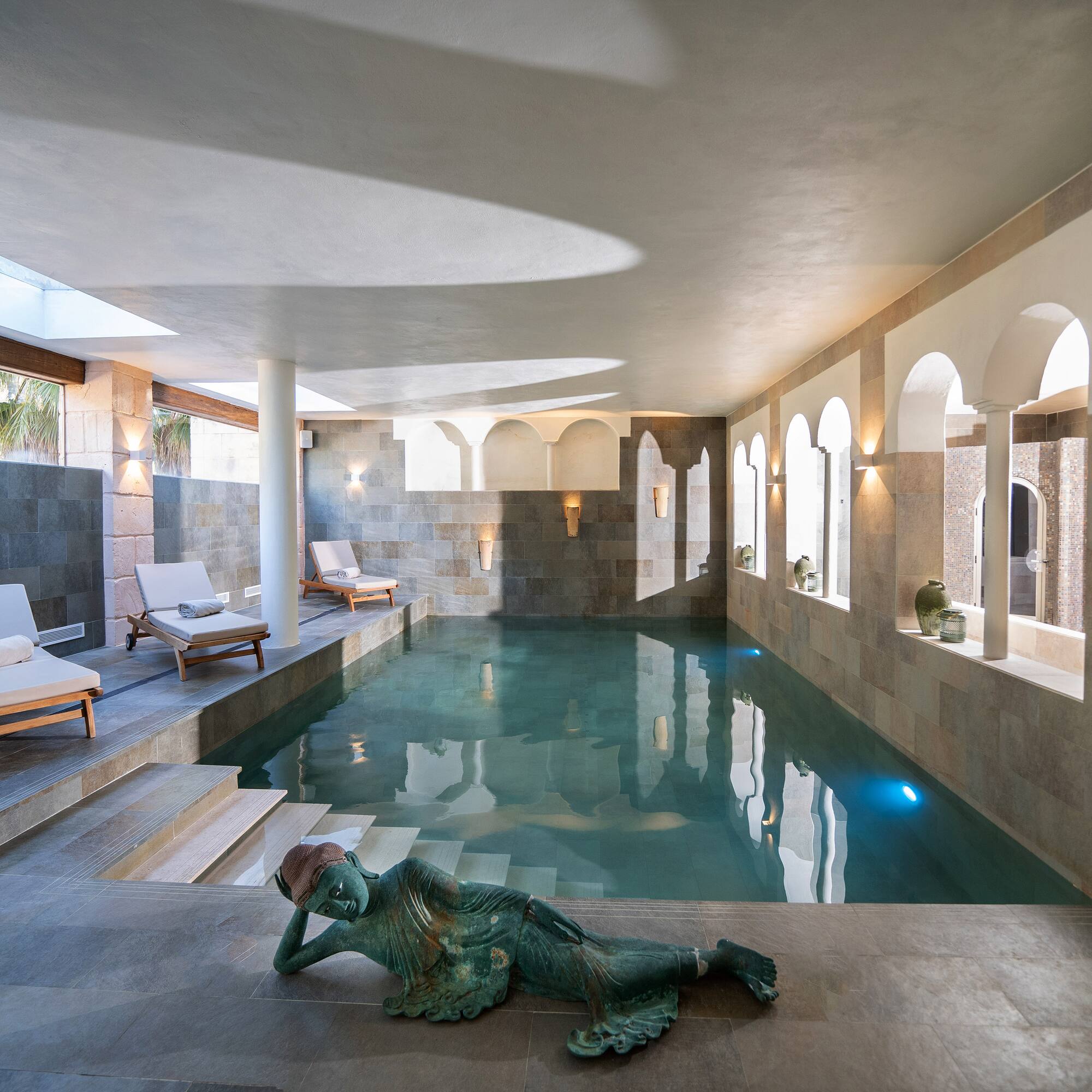 a swimming pool with a statue of a mermaid