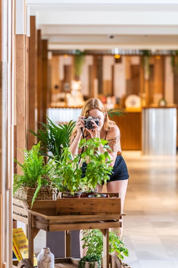 a woman taking a picture of a plant