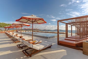 a pool with lounge chairs and umbrellas