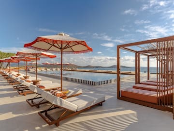 a pool with lounge chairs and umbrellas