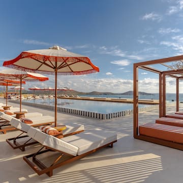a pool with lounge chairs and umbrellas