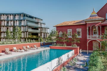 a pool with chairs and a building in the background