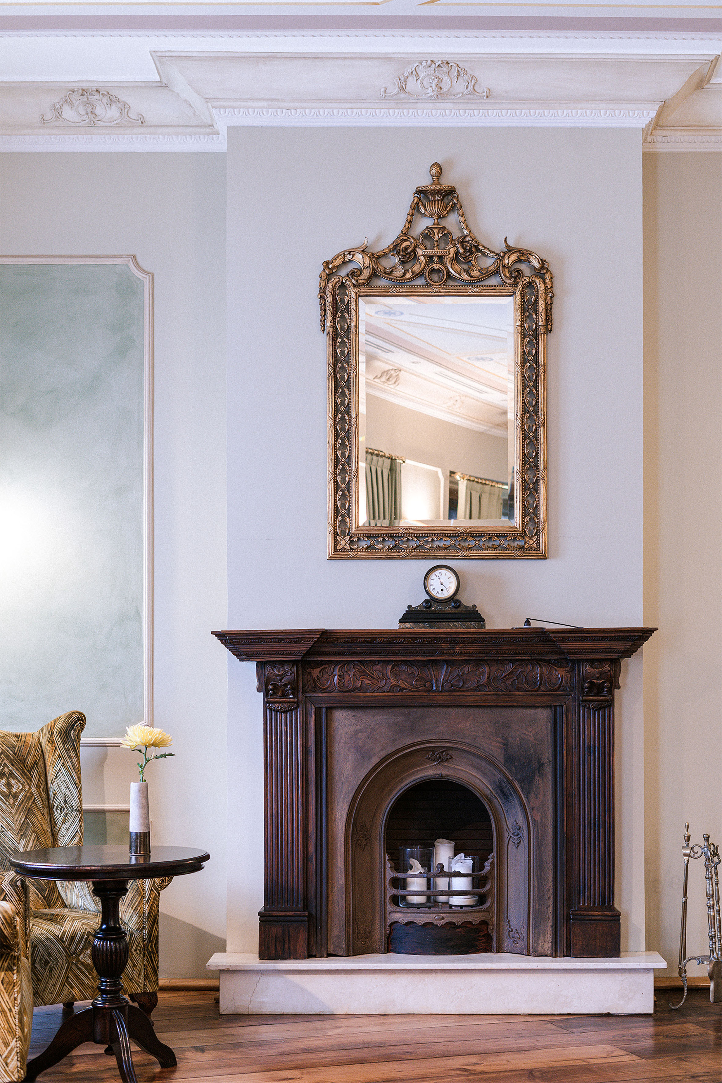 Ornate gold mirror over dark carved wood fireplace in elegant vintage room. - Galiana Pequeño - Palacio de Avilés Affiliated by Meliá, Avilés