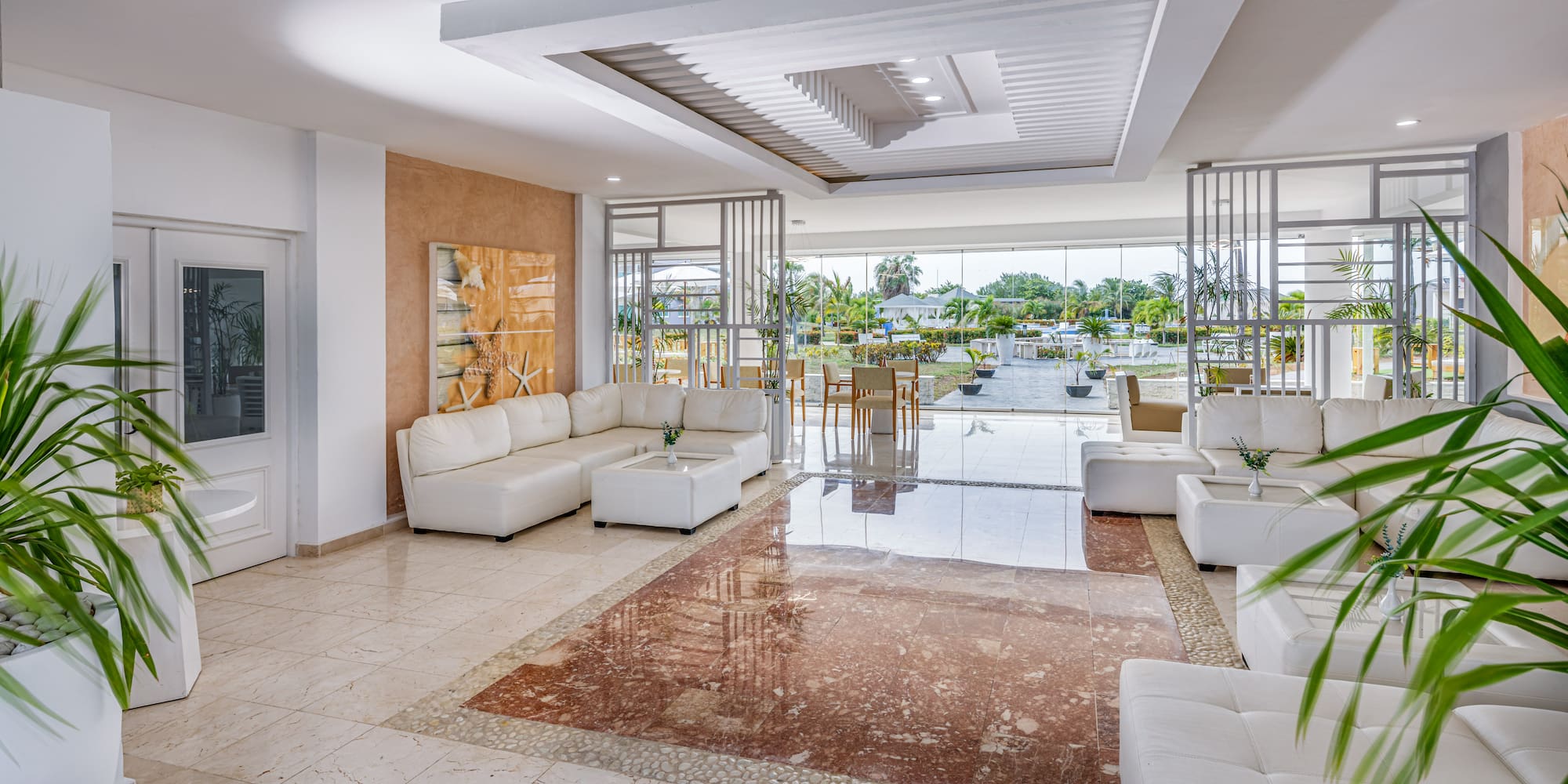a room with white furniture and a pool in the background