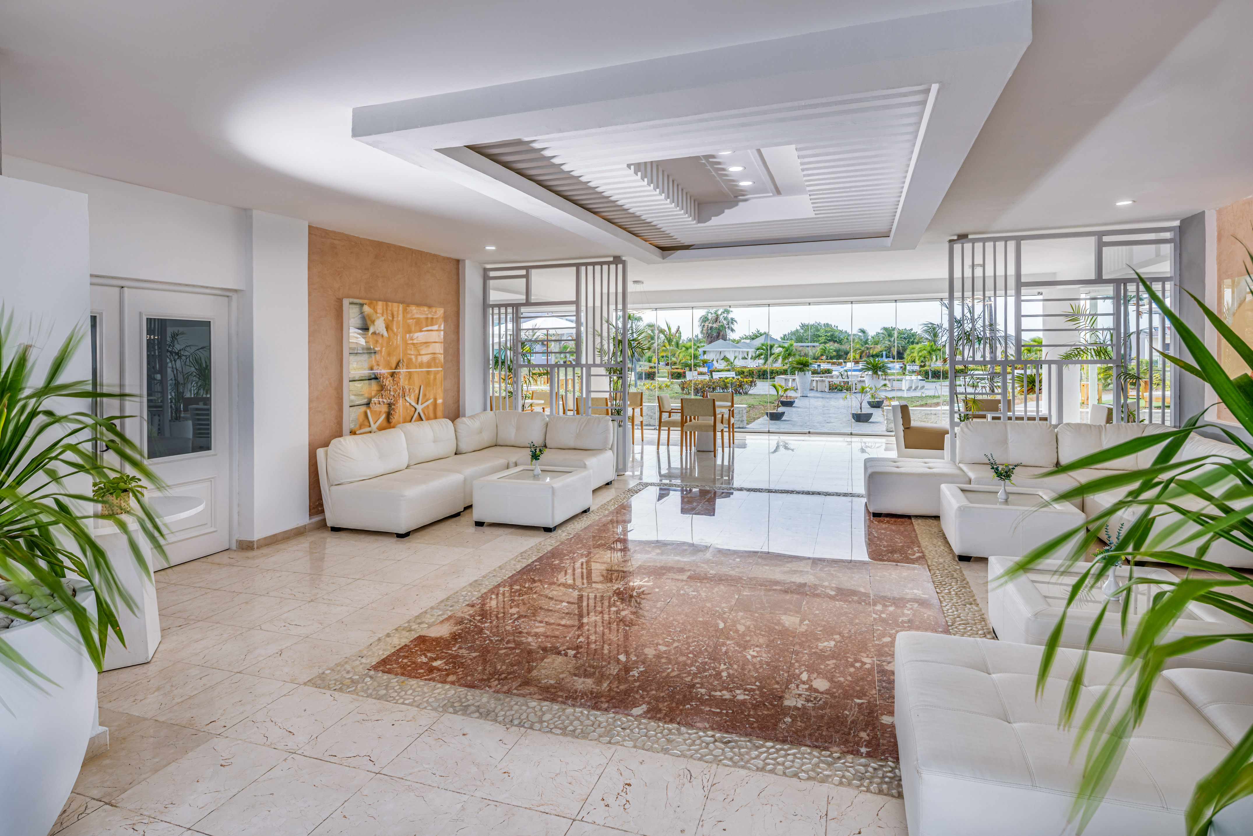 a room with white furniture and a pool in the background