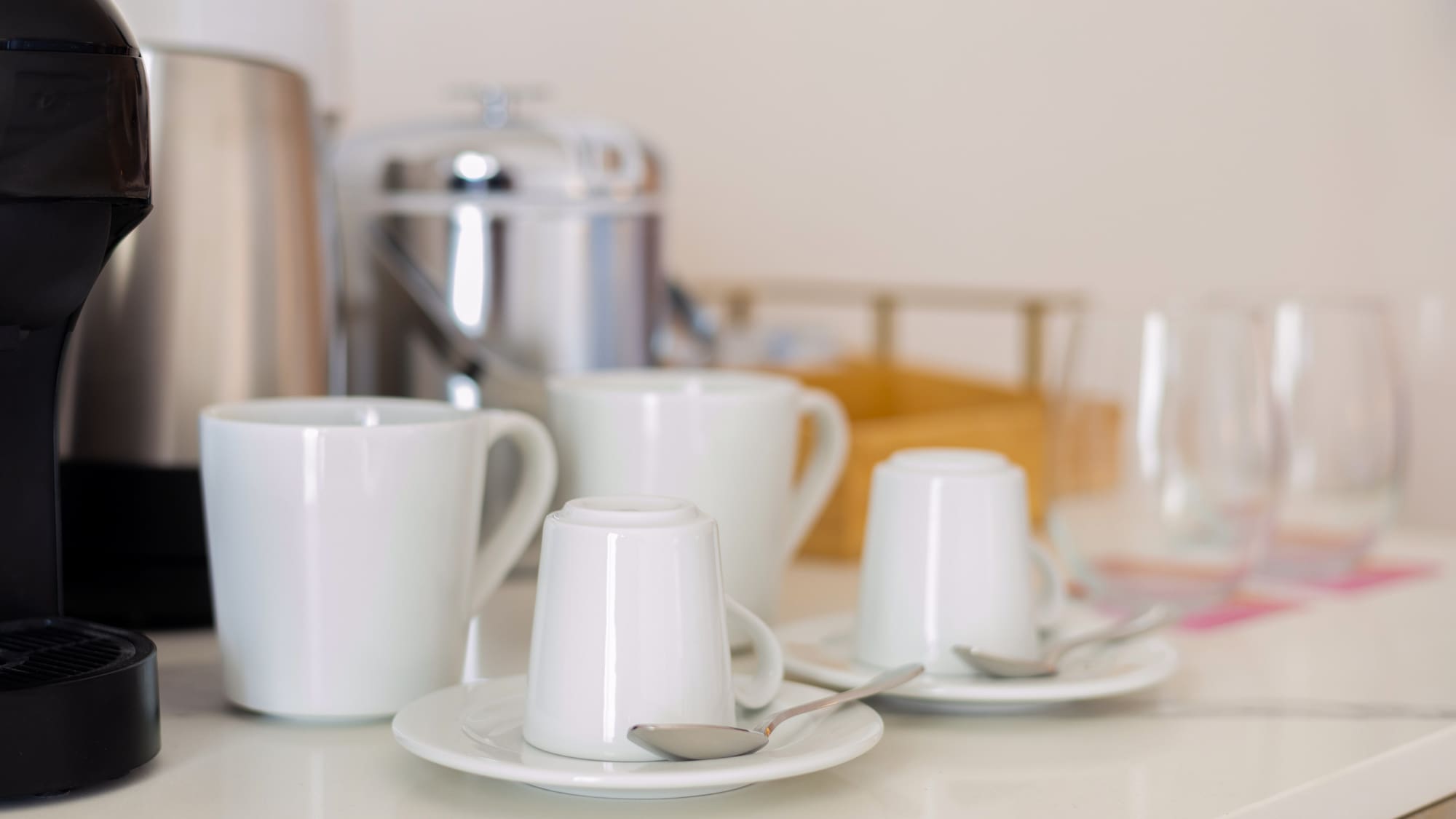 a group of white cups and saucers on a white counter