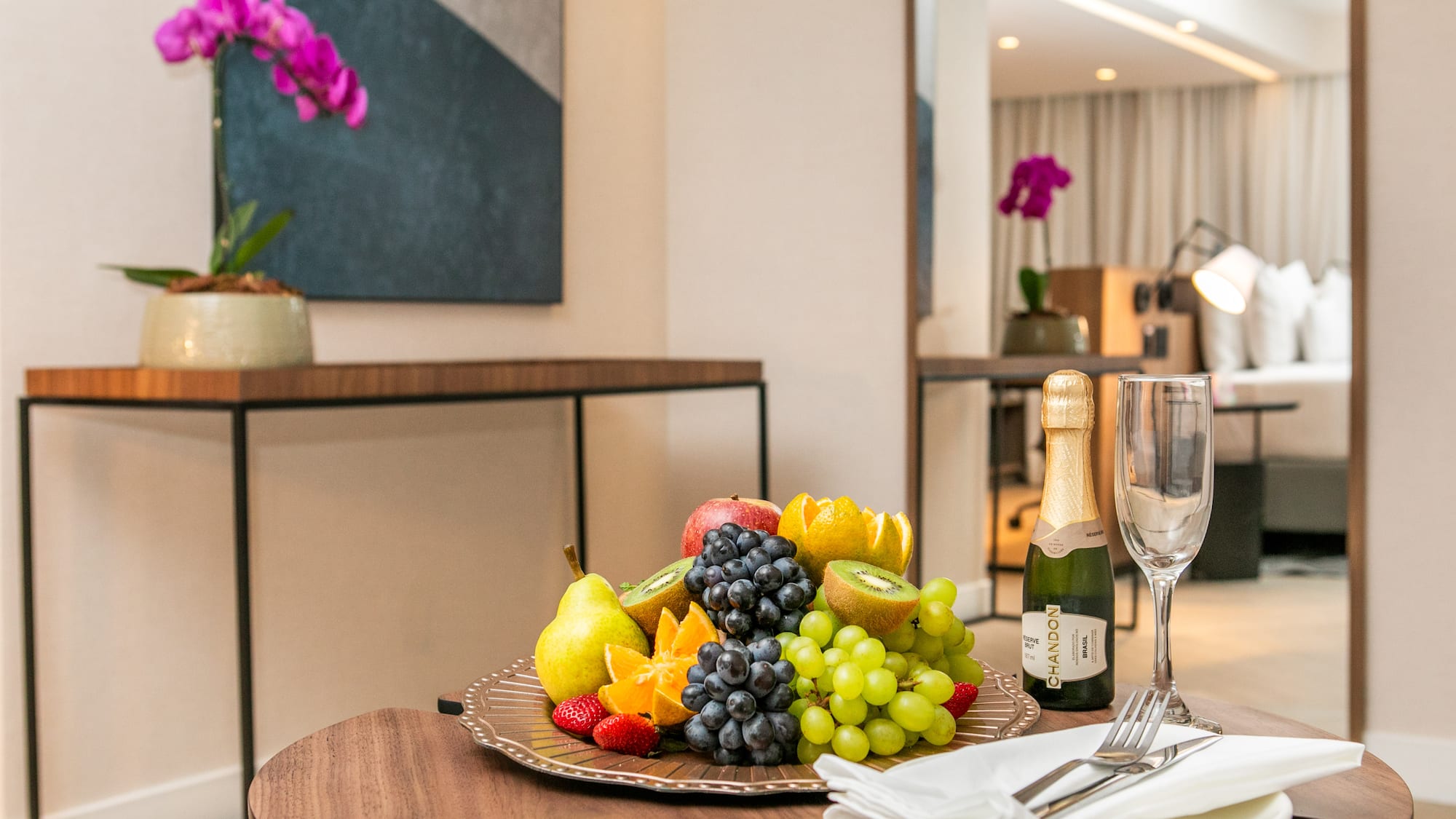 a plate of fruit and champagne on a table