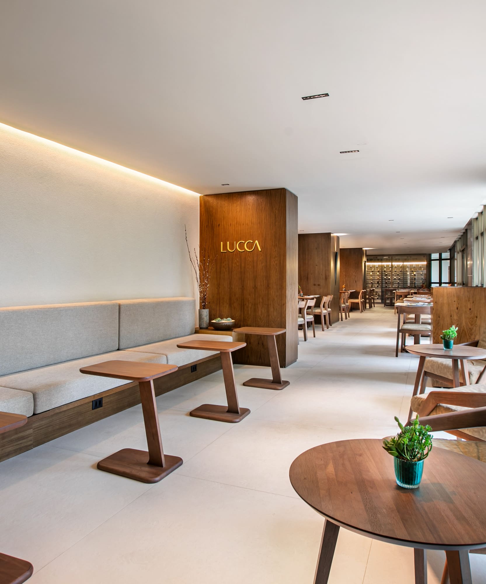 Lucca restaurant lounge: modern banquette, wood tables, natural light.