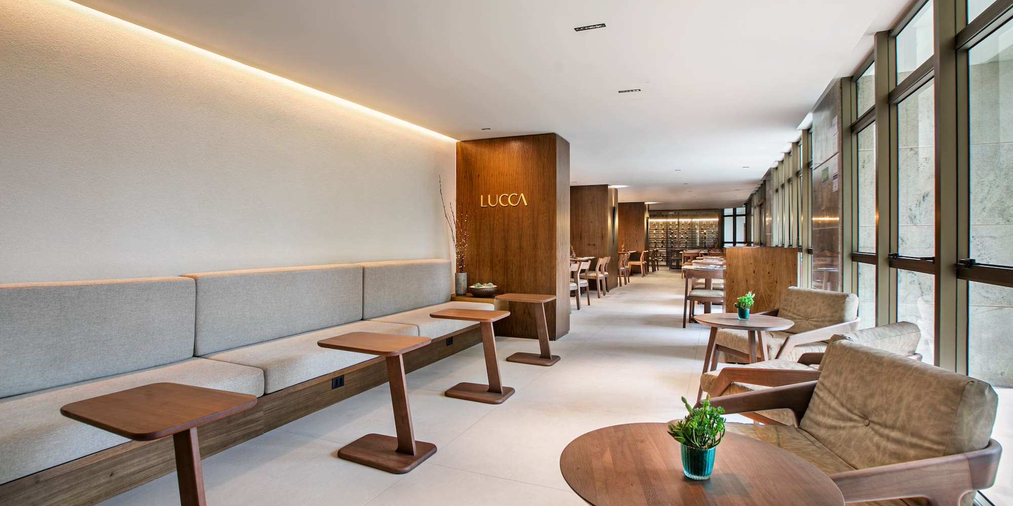 Lucca restaurant lounge: modern banquette, wood tables, natural light.