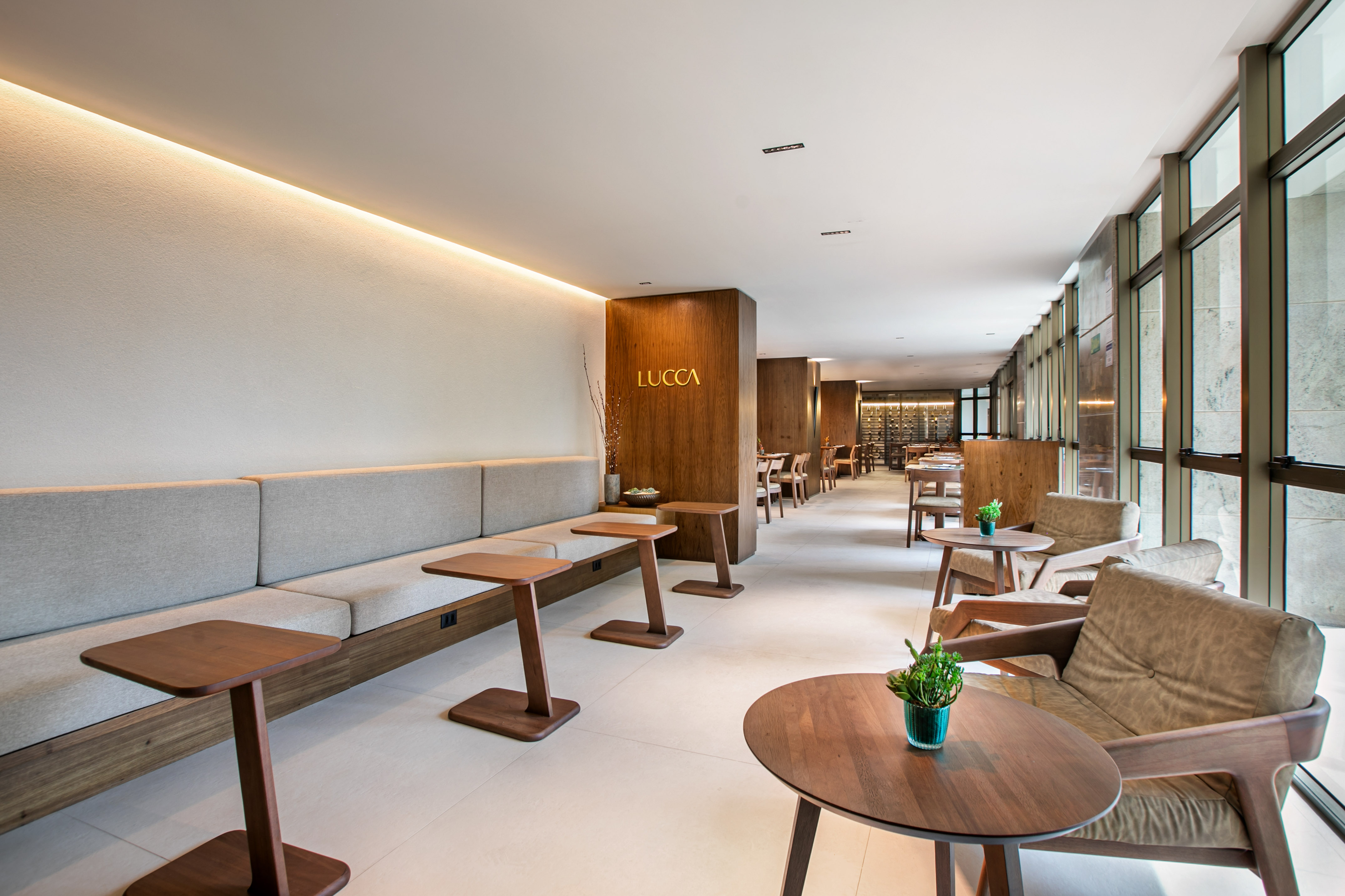 Lucca restaurant lounge: modern banquette, wood tables, natural light.
