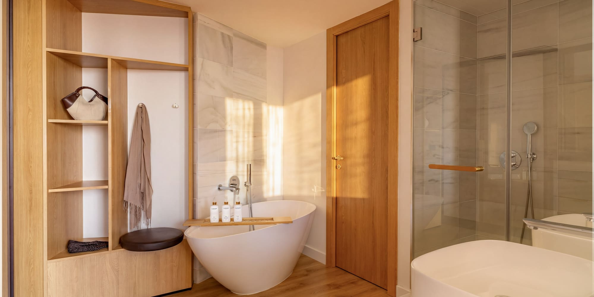 Modern bathroom with freestanding tub, wooden storage, glass shower, and white sink.
