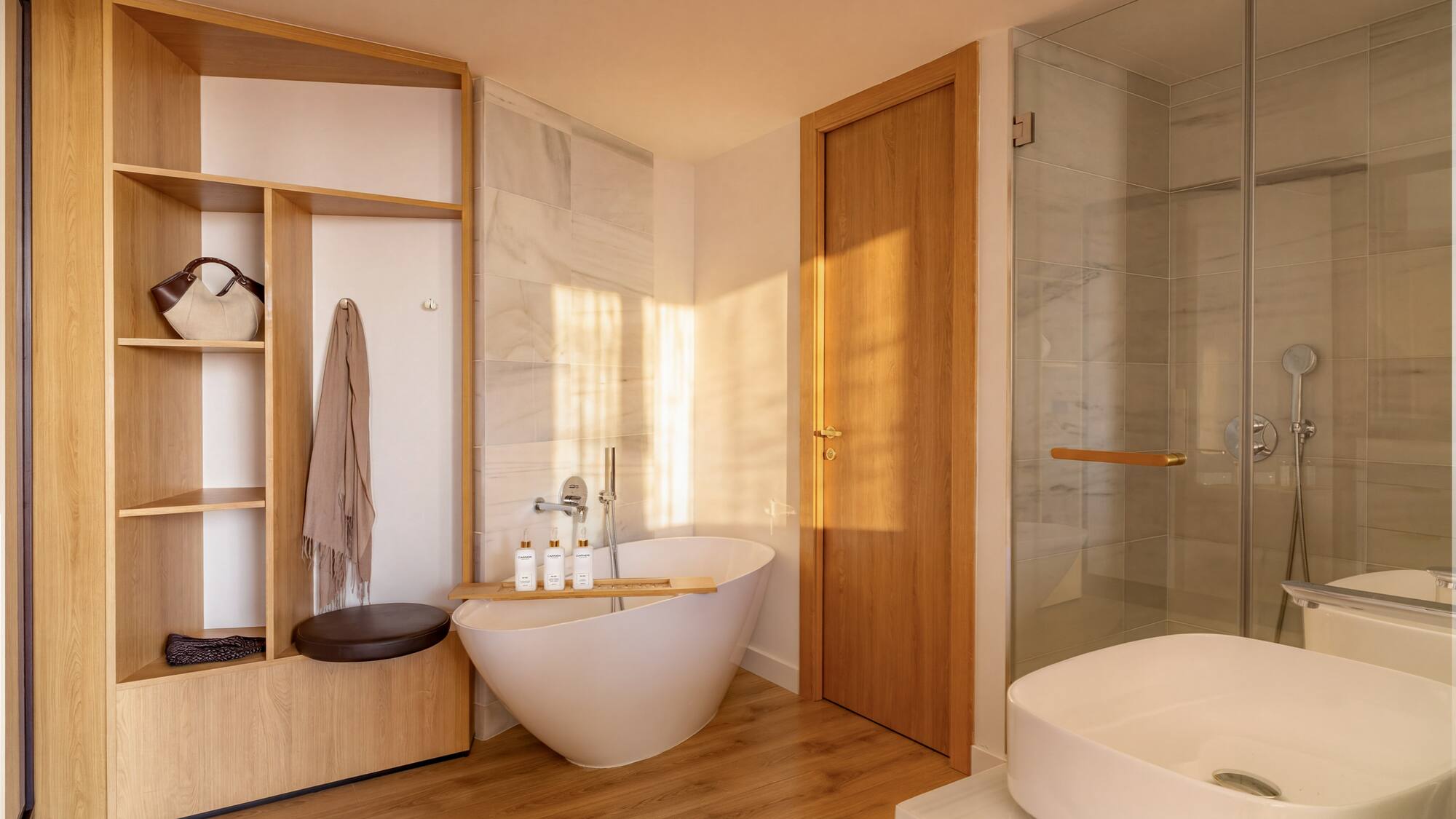Modern bathroom with freestanding tub, wooden storage, glass shower, and white sink.