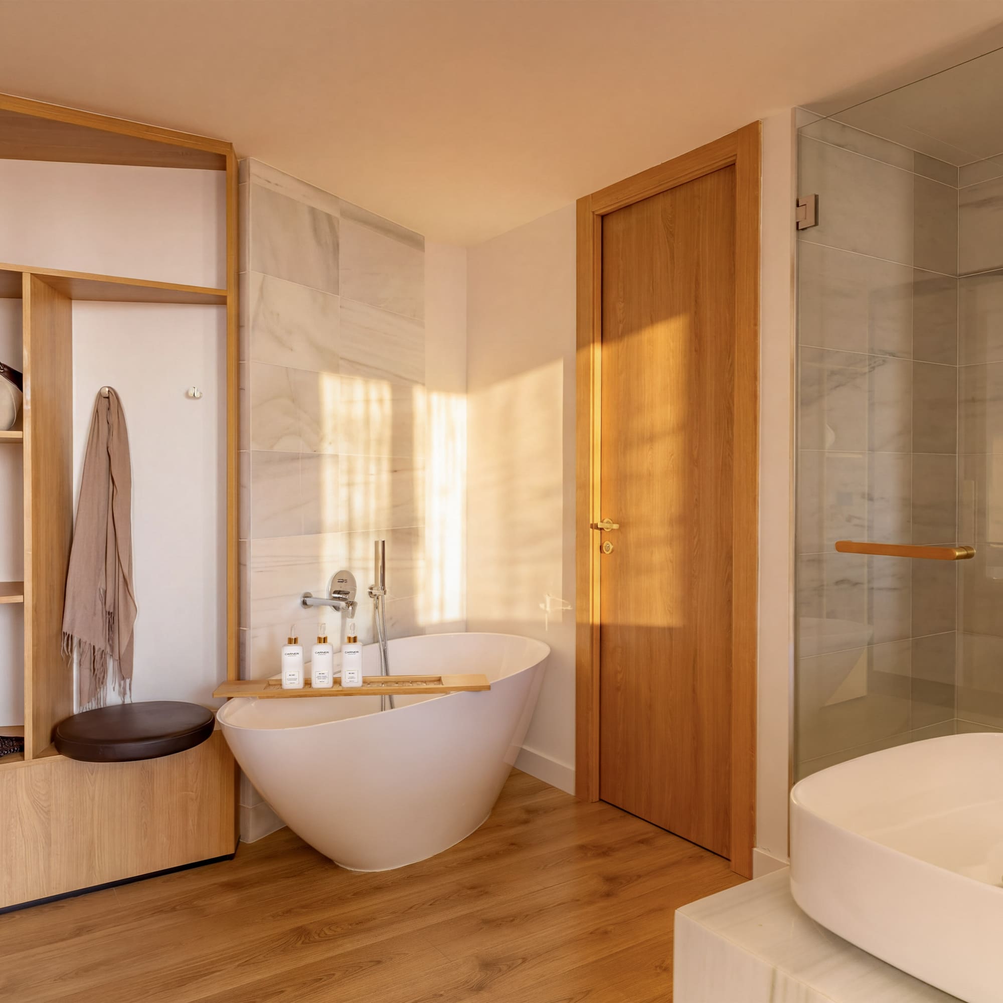 Modern bathroom with freestanding tub, wooden storage, glass shower, and white sink.