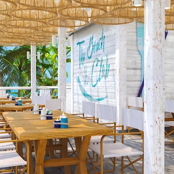 a table and chairs on a beach restaurant