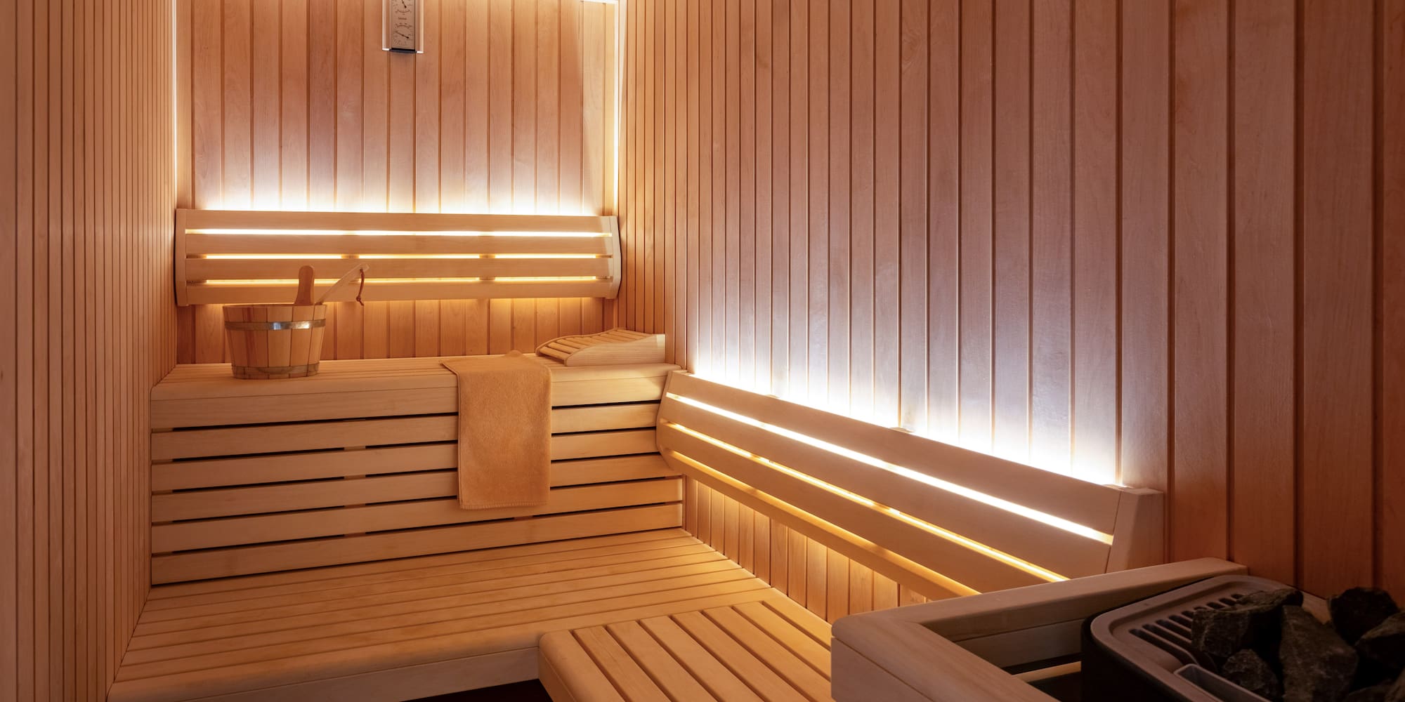 a wooden sauna with a bucket and a towel