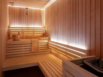 a wooden sauna with a bucket and a towel