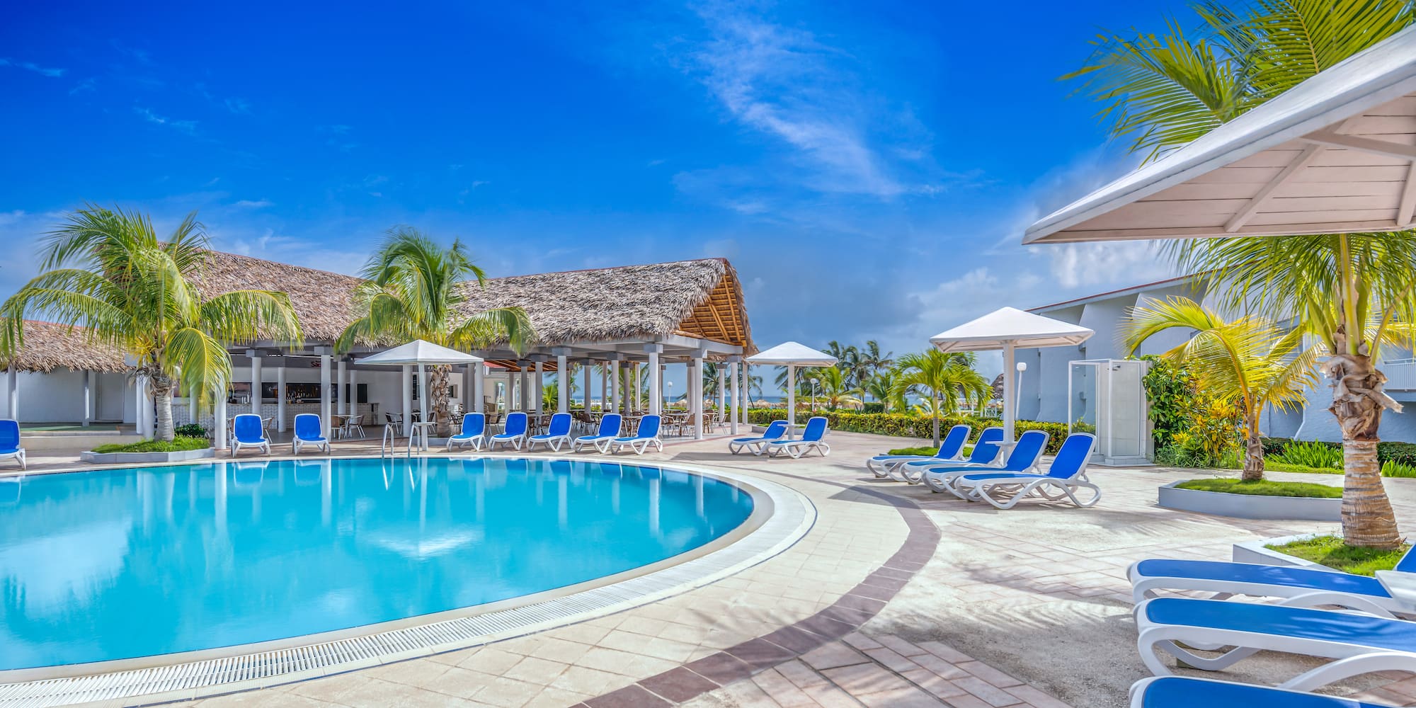 a pool with lounge chairs and umbrellas